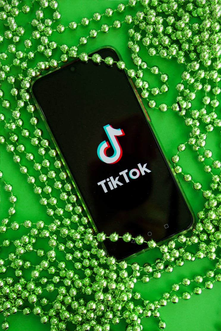 Tver, Russia - September 19, 2020: Tiktok App on Your Smartphone Screen and Christmas Beads on Green Background. TikTok Is a Popular Video Sharing Social Network Owned by ByteDance.